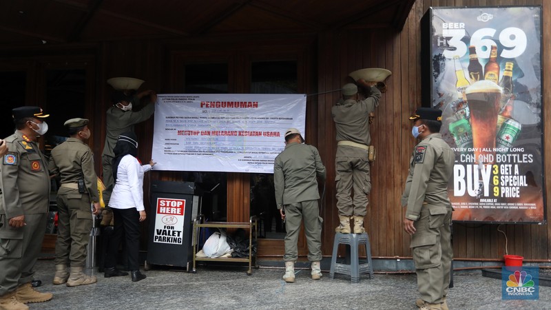 Petugas Satpol PP memasang spanduk penutupan Holywings Epicentrum, Jakarta, Selasa (28/6/2022). (CNBC Indonesia/Andrean Kristianto)