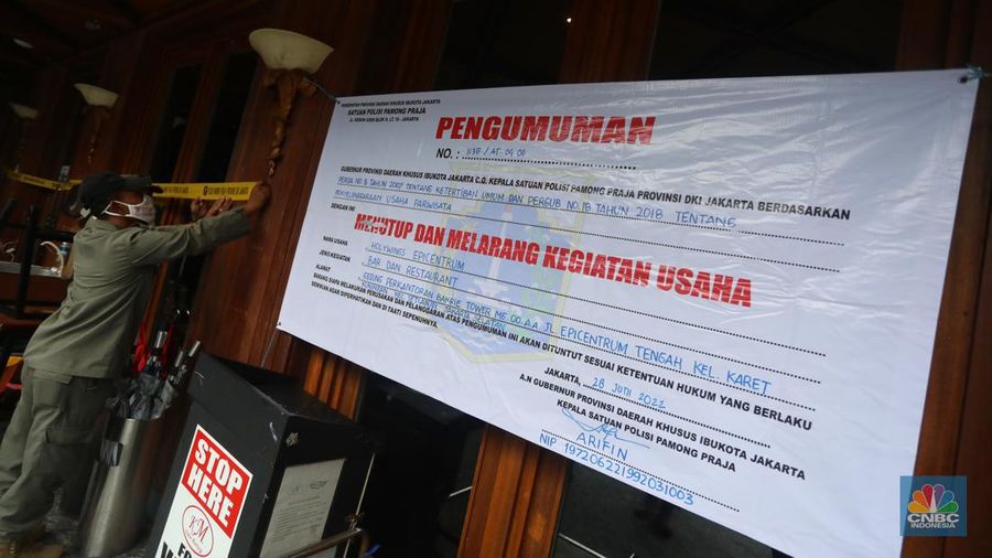Petugas Satpol PP memasang spanduk penutupan Holywings Epicentrum, Jakarta, Selasa (28/6/2022). (վ/Andrean Kristianto)
