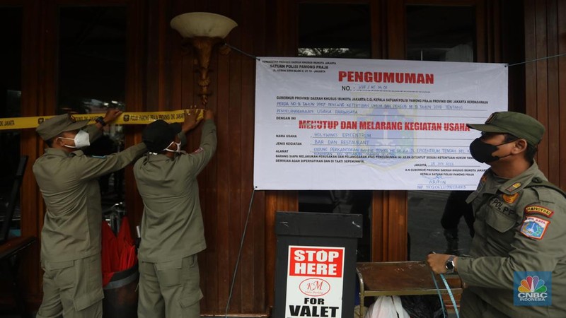 Petugas Satpol PP memasang spanduk penutupan Holywings Epicentrum, Jakarta, Selasa (28/6/2022). (CNBC Indonesia/Andrean Kristianto)