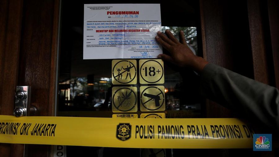 Petugas Satpol PP memasang spanduk penutupan Holywings Epicentrum, Jakarta, Selasa (28/6/2022). (վ/Andrean Kristianto)