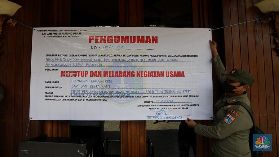 Petugas Satpol PP memasang spanduk penutupan Holywings Epicentrum, Jakarta, Selasa (28/6/2022). (CNBC Indonesia/Andrean Kristianto)