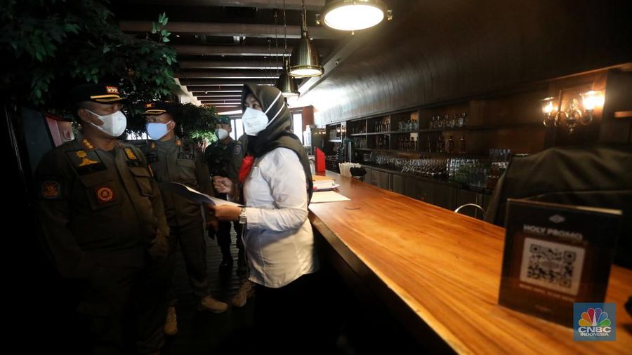 Petugas Satpol PP memasang spanduk penutupan Holywings Epicentrum, Jakarta, Selasa (28/6/2022). (CNBC Indonesia/Andrean Kristianto)