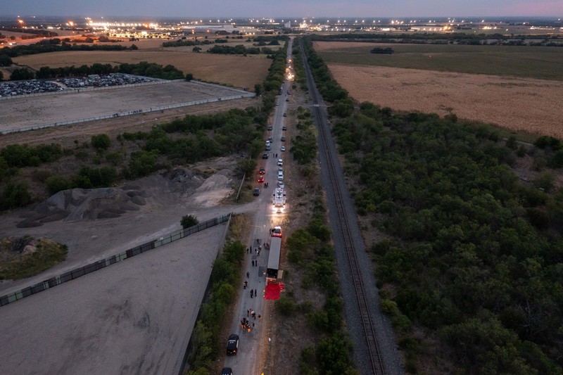 Petugas penegak hukum bekerja di lokasi di mana orang ditemukan tewas di dalam truk trailer di San Antonio, Texas, AS 27 Juni 2022. (REUTERS/KAYLEE GREENLEE BEAL)