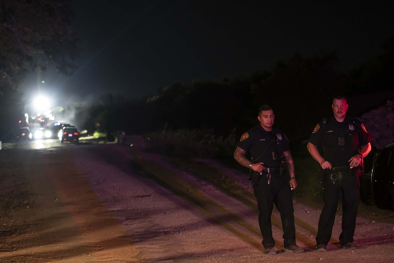 Petugas penegak hukum bekerja di lokasi di mana orang ditemukan tewas di dalam truk trailer di San Antonio, Texas, AS 27 Juni 2022. (REUTERS/KAYLEE GREENLEE BEAL)