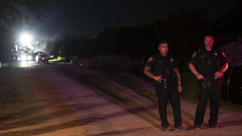 Petugas penegak hukum bekerja di lokasi di mana orang ditemukan tewas di dalam truk trailer di San Antonio, Texas, AS 27 Juni 2022. (REUTERS/KAYLEE GREENLEE BEAL)