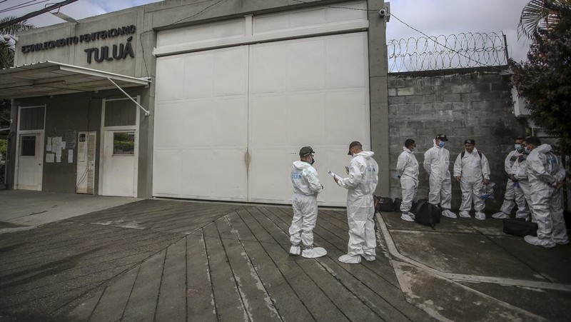 Penyelidik forensik berdiri di dekat kantong mayat setelah kebakaran mematikan di sebuah penjara di Tulua, Kolombia, Selasa, 28 Juni 2022. Pihak berwenang mengatakan setidaknya 51 orang tewas setelah kebakaran terjadi selama apa yang tampaknya merupakan percobaan kerusuhan Selasa pagi. (AP/Andres Quintero)