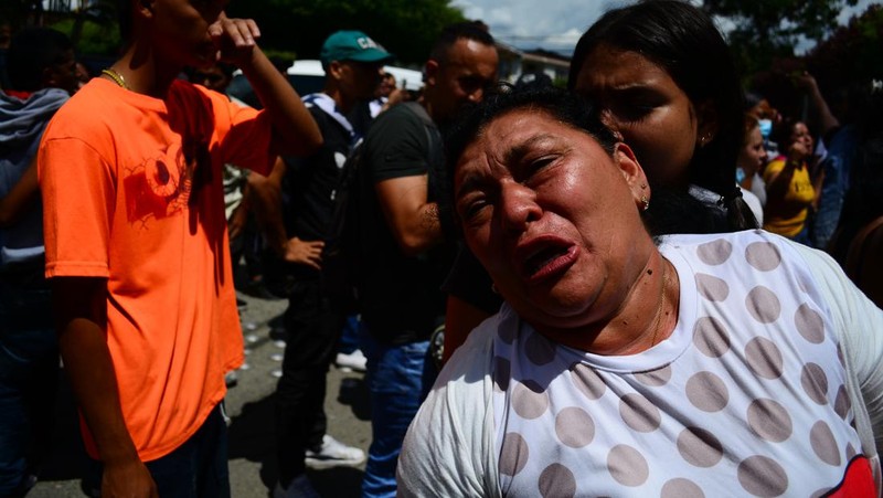 Penyelidik forensik berdiri di dekat kantong mayat setelah kebakaran mematikan di sebuah penjara di Tulua, Kolombia, Selasa, 28 Juni 2022. Pihak berwenang mengatakan setidaknya 51 orang tewas setelah kebakaran terjadi selama apa yang tampaknya merupakan percobaan kerusuhan Selasa pagi. (AP/Andres Quintero)