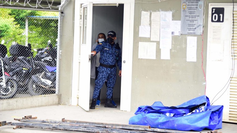 Penyelidik forensik berdiri di dekat kantong mayat setelah kebakaran mematikan di sebuah penjara di Tulua, Kolombia, Selasa, 28 Juni 2022. Pihak berwenang mengatakan setidaknya 51 orang tewas setelah kebakaran terjadi selama apa yang tampaknya merupakan percobaan kerusuhan Selasa pagi. (AP/Andres Quintero)
