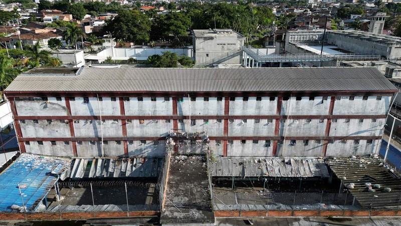 Penyelidik forensik berdiri di dekat kantong mayat setelah kebakaran mematikan di sebuah penjara di Tulua, Kolombia, Selasa, 28 Juni 2022. Pihak berwenang mengatakan setidaknya 51 orang tewas setelah kebakaran terjadi selama apa yang tampaknya merupakan percobaan kerusuhan Selasa pagi. (AP/Andres Quintero)