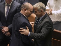 Perdana Menteri Israel Naftali Bennett, kiri, dan Menteri Luar Negeri Yair Lapid bereaksi setelah pemungutan suara pada RUU untuk membubarkan parlemen di Knesset, parlemen Israel, di Yerusalem, Kamis, 30 Juni 2022. (AP/Ariel Schalit)