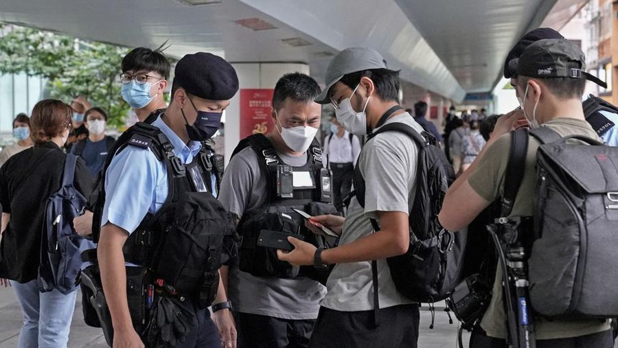 Polisi berjaga di dekat Stasiun West Kowloon di Hong Kong pada 30 Juni 2022, menjelang kedatangan Presiden China Xi Jinping di Hong Kong untuk merayakan ulang tahun ke-25 serah terima Hong Kong dari Inggris ke China yang berlangsung pada 1 Juli. (AFP via Getty Images/ISAAC LAWRENCE)