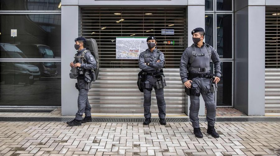 Polisi berjaga di dekat Stasiun West Kowloon di Hong Kong pada 30 Juni 2022, menjelang kedatangan Presiden China Xi Jinping di Hong Kong untuk merayakan ulang tahun ke-25 serah terima Hong Kong dari Inggris ke China yang berlangsung pada 1 Juli. (AFP via Getty Images/ISAAC LAWRENCE)
