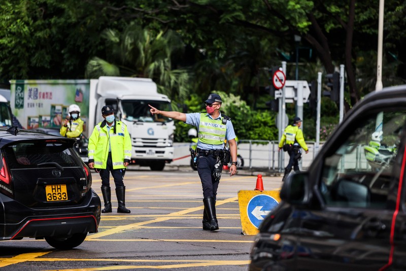 Polisi berjaga di dekat Stasiun West Kowloon di Hong Kong pada 30 Juni 2022, menjelang kedatangan Presiden China Xi Jinping di Hong Kong untuk merayakan ulang tahun ke-25 serah terima Hong Kong dari Inggris ke China yang berlangsung pada 1 Juli. (AFP via Getty Images/ISAAC LAWRENCE)