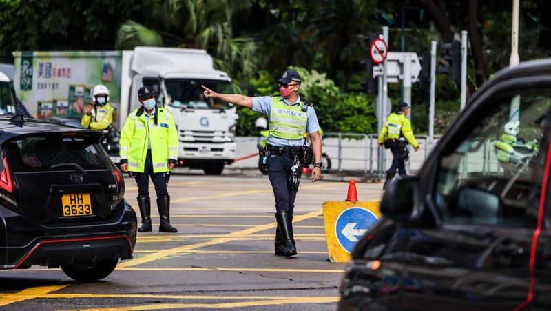 Polisi berjaga di dekat Stasiun West Kowloon di Hong Kong pada 30 Juni 2022, menjelang kedatangan Presiden China Xi Jinping di Hong Kong untuk merayakan ulang tahun ke-25 serah terima Hong Kong dari Inggris ke China yang berlangsung pada 1 Juli. (AFP via Getty Images/ISAAC LAWRENCE)