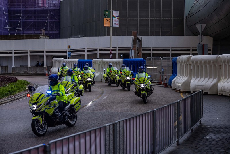 Polisi berjaga di dekat Stasiun West Kowloon di Hong Kong pada 30 Juni 2022, menjelang kedatangan Presiden China Xi Jinping di Hong Kong untuk merayakan ulang tahun ke-25 serah terima Hong Kong dari Inggris ke China yang berlangsung pada 1 Juli. (AFP via Getty Images/ISAAC LAWRENCE)