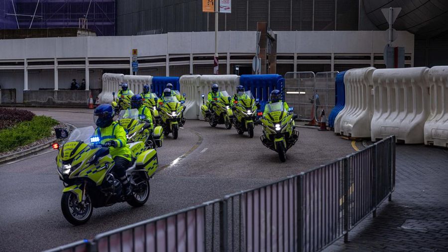 Polisi berjaga di dekat Stasiun West Kowloon di Hong Kong pada 30 Juni 2022, menjelang kedatangan Presiden China Xi Jinping di Hong Kong untuk merayakan ulang tahun ke-25 serah terima Hong Kong dari Inggris ke China yang berlangsung pada 1 Juli. (AFP via Getty Images/ISAAC LAWRENCE)