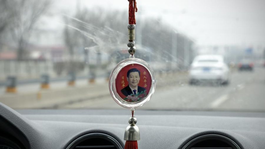 Potret Presiden China Xi Jinping terlihat pada jimat keberuntungan di dalam mobil pada 24 Maret 2022 di Beijing, China. (Getty Images/Andrea Verdelli)