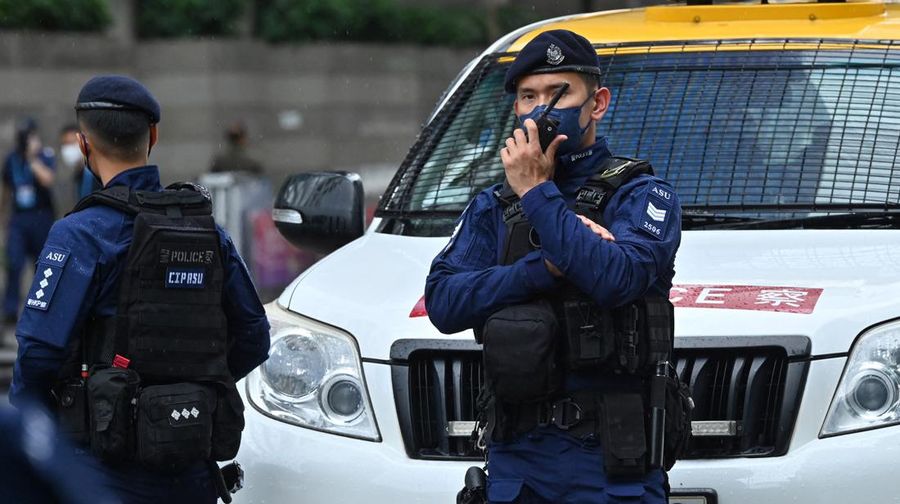 Polisi berjaga di dekat Stasiun West Kowloon di Hong Kong pada 30 Juni 2022, menjelang kedatangan Presiden China Xi Jinping di Hong Kong untuk merayakan ulang tahun ke-25 serah terima Hong Kong dari Inggris ke China yang berlangsung pada 1 Juli. (AFP via Getty Images/ISAAC LAWRENCE)