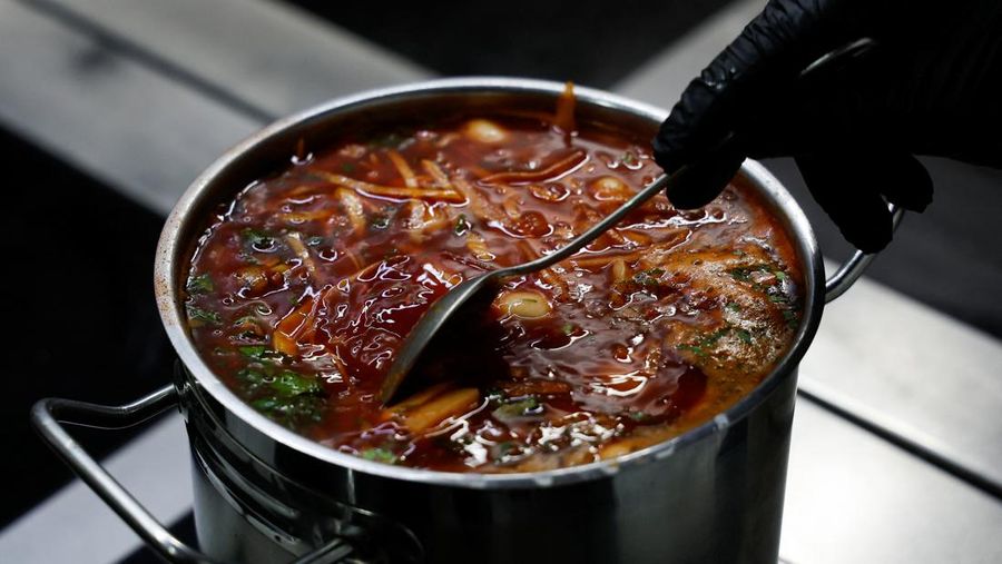 Koki Ukraina Yevhenii Marshal memasak borshch di restoran masakan tradisional, saat serangan Rusia di Ukraina berlanjut, di Kyiv, Ukraina, Jumat (1/7/2022). (REUTERS/Valentyn Ogirenko)