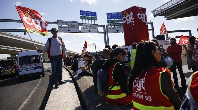 Aksi unjuk rasa pekerja di bandara Roissy-Charles-de-Gaulle di Paris, Prancis. Puluhan penerbangan di bandara tersibuk di Prancis dibatalkan sejak Jumat hingga Sabtu ini, 2 Juli 2022, yang dipicu perseteruan terkait masalah upah dan kondisi lingkungan kerja. Unjuk rasa ini terjadi di kalangan petugas pemadam kebakaran area bandara. (AP/Thomas Padilla)