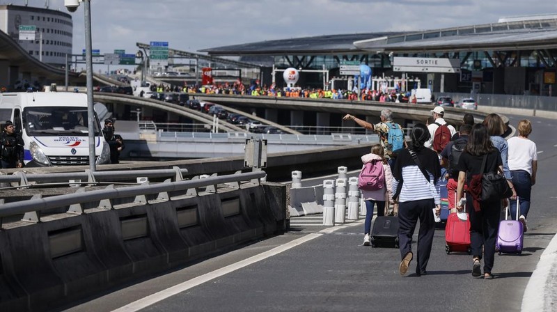 Aksi unjuk rasa pekerja di bandara Roissy-Charles-de-Gaulle di Paris, Prancis. Puluhan penerbangan di bandara tersibuk di Prancis dibatalkan sejak Jumat hingga Sabtu ini, 2 Juli 2022, yang dipicu perseteruan terkait masalah upah dan kondisi lingkungan kerja. Unjuk rasa ini terjadi di kalangan petugas pemadam kebakaran area bandara. (AP/Thomas Padilla)