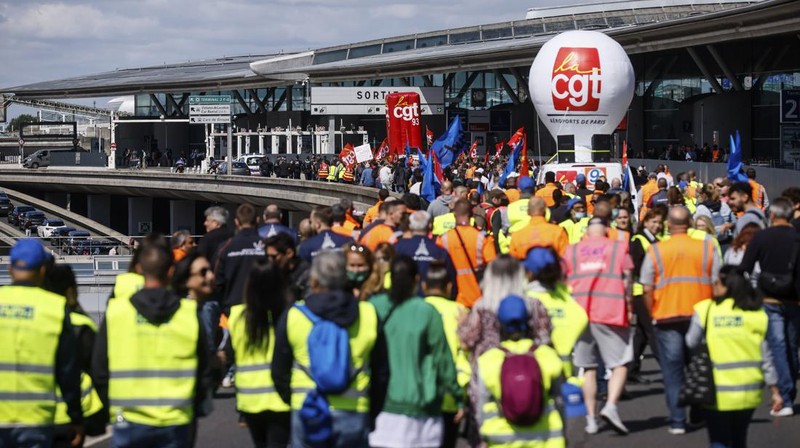 Aksi unjuk rasa pekerja di bandara Roissy-Charles-de-Gaulle di Paris, Prancis. Puluhan penerbangan di bandara tersibuk di Prancis dibatalkan sejak Jumat hingga Sabtu ini, 2 Juli 2022, yang dipicu perseteruan terkait masalah upah dan kondisi lingkungan kerja. Unjuk rasa ini terjadi di kalangan petugas pemadam kebakaran area bandara. (AP/Thomas Padilla)