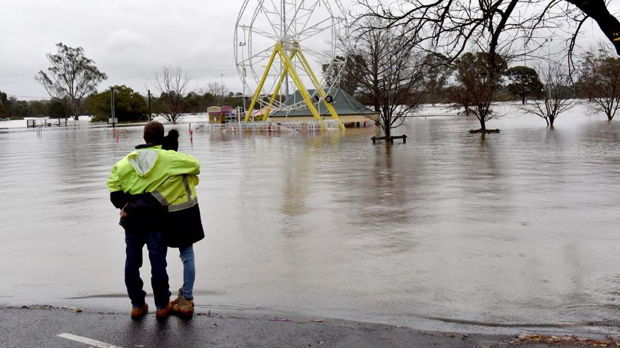 Keluarga dievakuasi oleh pekerja Layanan Darurat Negara karena meningkatnya air banjir di Bligh Park, Sydney, Australia, Senin (4/7/2022). Ribuan penduduk terpaksa meninggalkan rumah mereka semalaman dan sejumlah perintah evakuasi diberlakukan di seluruh Sydney saat hujan lebat dan banjir terus berlanjut. (Photo by Jenny Evans/Getty Images)