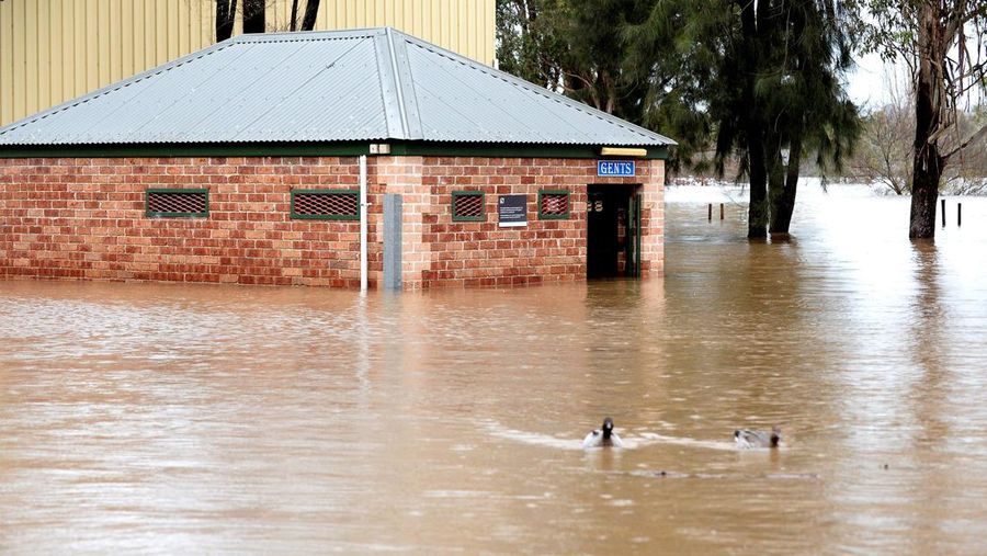 Rumah terendam banjir akibat hujan deras di pinggiran Camden, Sydney, Minggu (3/7/2022). Ribuan warga Australia diperintahkan untuk mengungsi dari rumah mereka di Sydney pada 3 Juli saat hujan deras mengguyur kota terbesar di negara itu dan air banjir menggenangi wilayah tersebut. pinggiran. (Photo by Muhammad FAROOQ/AFP via Getty Images)