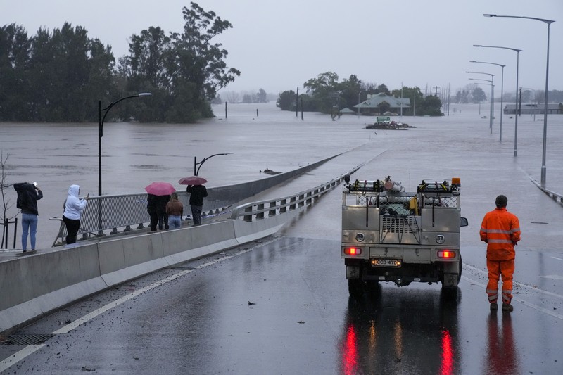 Banjir di Sydney Australia Keluarga dievakuasi oleh pekerja Layanan Darurat Negara karena meningkatnya air banjir di Bligh Park, Sydney, Australia, Senin (4/7/2022). Ribuan penduduk terpaksa meninggalkan rumah mereka semalaman dan sejumlah perintah evakuasi diberlakukan di seluruh Sydney saat hujan lebat dan banjir terus berlanjut. (Photo by Jenny Evans/Getty Images)