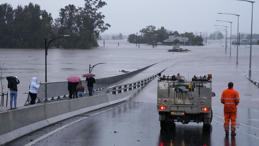 Sebuah kendaraan darurat memblokir akses ke Jembatan Windsor yang banjir di pinggiran Sydney, Australia, Senin (4/7/2022). Lebih dari 30.000 penduduk Sydney dan sekitarnya telah diperintahkan untuk mengungsi atau bersiap-siap meninggalkan rumah mereka pada Senin saat menghadapi banjir terburuk dalam 18 bulan. (AP Photo/Mark Baker)