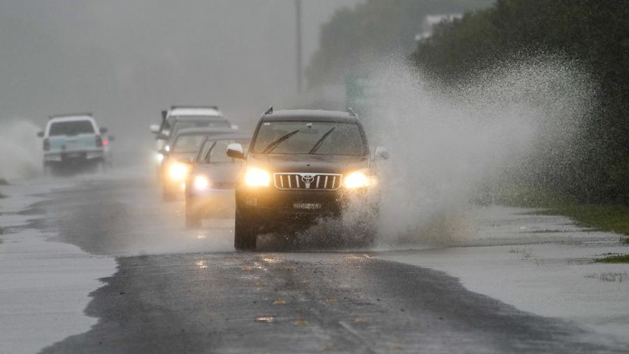 Keluarga dievakuasi oleh pekerja Layanan Darurat Negara karena meningkatnya air banjir di Bligh Park, Sydney, Australia, Senin (4/7/2022). Ribuan penduduk terpaksa meninggalkan rumah mereka semalaman dan sejumlah perintah evakuasi diberlakukan di seluruh Sydney saat hujan lebat dan banjir terus berlanjut. (Photo by Jenny Evans/Getty Images)