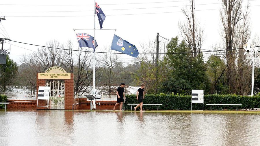 Keluarga dievakuasi oleh pekerja Layanan Darurat Negara karena meningkatnya air banjir di Bligh Park, Sydney, Australia, Senin (4/7/2022). Ribuan penduduk terpaksa meninggalkan rumah mereka semalaman dan sejumlah perintah evakuasi diberlakukan di seluruh Sydney saat hujan lebat dan banjir terus berlanjut. (Photo by Jenny Evans/Getty Images)