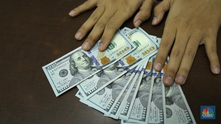 Pekerja memperlihatkan uang dolar di salah satu gerai money changer di Jakarta, Senin (4/7/2022).  (CNBC Indonesia/ Tri Susilo)