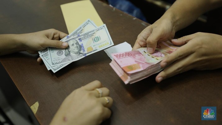 Pekerja memperlihatkan uang dolar di salah satu gerai money changer di Jakarta, Senin (4/7/2022).  (CNBC Indonesia/ Tri Susilo)