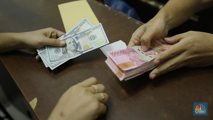 Pekerja memperlihatkan uang dolar di salah satu gerai money changer di Jakarta, Senin (4/7/2022). (CNBC Indonesia/ Tri Susilo)