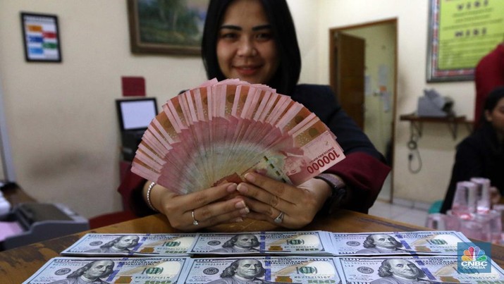 Pekerja pusat penukaran mata uang asing menghitung uang Dollar AS di gerai penukaran mata uang asing Dolarindo di Melawai, Jakarta, Senin (4/7/2022). (CNBC Indonesia/ Muhammad Sabki)