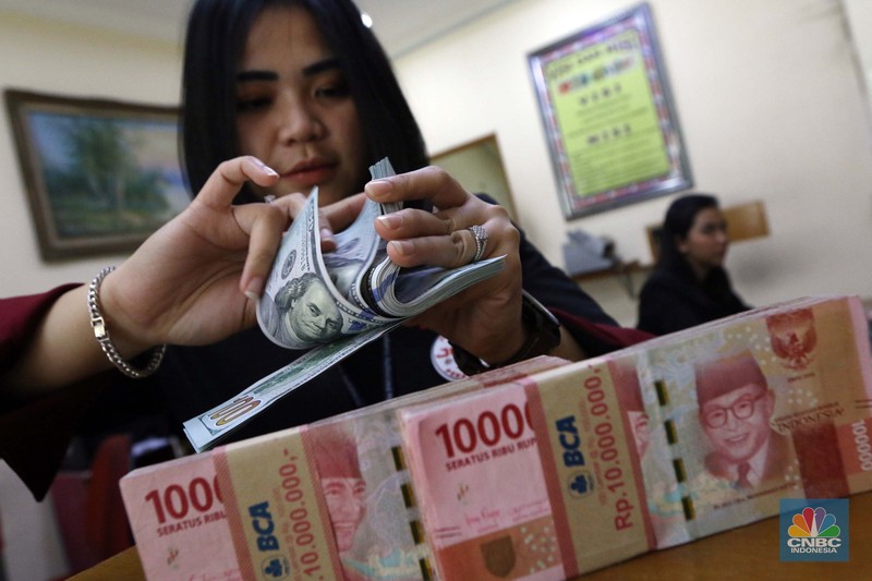 Ilustrasi dolar Amerika Serikat (AS) Pekerja pusat penukaran mata uang asing menghitung uang Dollar AS di gerai penukaran mata uang asing Dolarindo di Melawai, Jakarta, Senin (4/7/2022). (CNBC Indonesia/ Muhammad Sabki)