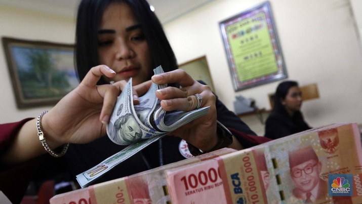 Ilustrasi dolar Amerika Serikat (AS) Pekerja pusat penukaran mata uang asing menghitung uang Dollar AS di gerai penukaran mata uang asing Dolarindo di Melawai, Jakarta, Senin (4/7/2022). (CNBC Indonesia/ Muhammad Sabki)