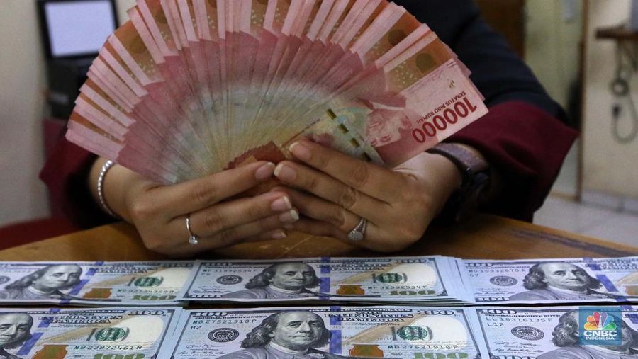 Pekerja pusat penukaran mata uang asing menghitung uang Dollar AS di gerai penukaran mata uang asing Dolarindo di Melawai, Jakarta, Senin (4/7/2022). (վ/ Muhammad Sabki)