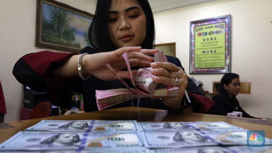 Pekerja pusat penukaran mata uang asing menghitung uang Dollar AS di gerai penukaran mata uang asing Dolarindo di Melawai, Jakarta, Senin (4/7/2022). (CNBC Indonesia/ Muhammad Sabki)