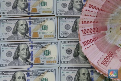 Pekerja pusat penukaran mata uang asing menghitung uang Dollar AS di gerai penukaran mata uang asing Dolarindo di Melawai, Jakarta, Senin (4/7/2022). (CNBC Indonesia/ Muhammad Sabki)