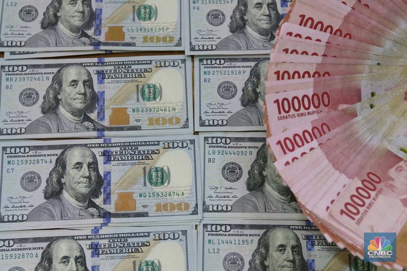 Pekerja pusat penukaran mata uang asing menghitung uang Dollar AS di gerai penukaran mata uang asing Dolarindo di Melawai, Jakarta, Senin (4/7/2022). (CNBC Indonesia/ Muhammad Sabki)