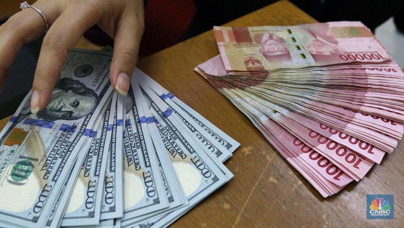 Pekerja pusat penukaran mata uang asing menghitung uang Dollar AS di gerai penukaran mata uang asing Dolarindo di Melawai, Jakarta, Senin (4/7/2022). (CNBC Indonesia/ Muhammad Sabki)