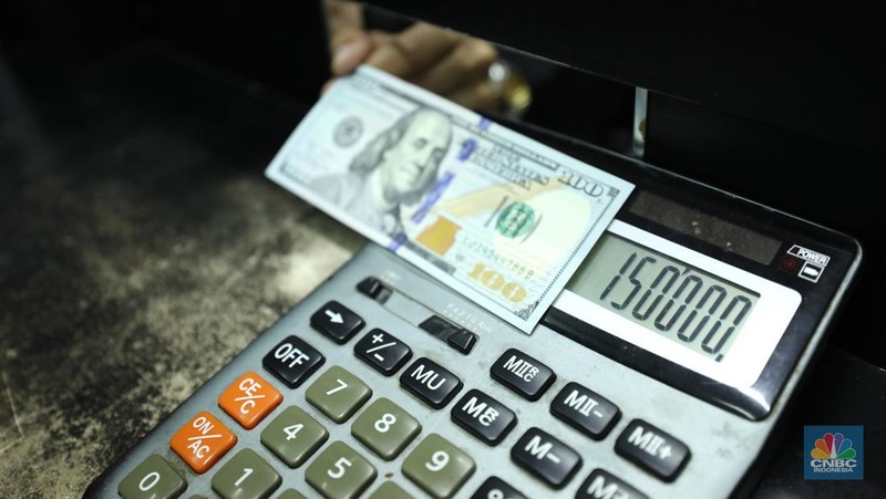 Pekerja pusat penukaran mata uang asing menghitung uang Dollar AS di gerai penukaran mata uang asing Dolarindo di Melawai, Jakarta, Senin (4/7/2022). (CNBC Indonesia/ Muhammad Sabki)