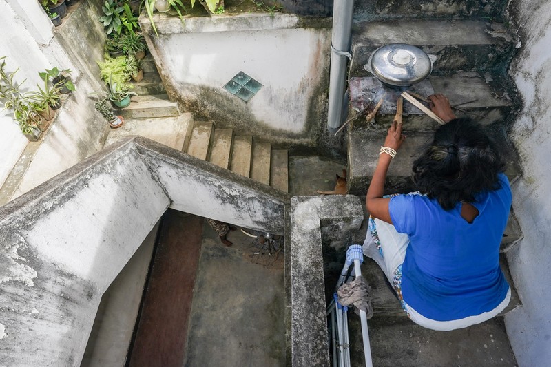 Warga memasak makanan dengan tungku kayu di luar rumah susunnya di Kolombo, Sri Lanka, Senin (4/7/2022). Sri Lanka kehabisan bahan bakar bensin dan diesel usai pengiriman pasokan ditunda tanpa kepastian. (Photo by Thilina Kaluthotage/NurPhoto via Getty Images)