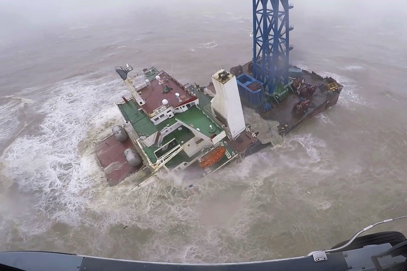 Kapal kargo Tenggelam di Laut Cina Selatan Sebuah helikopter dengan anggota awak penyelamat mendekati kapal yang tenggelam di Laut Cina Selatan, 300 kilometer (186 mil) selatan Hong Kong, Sabtu (2/7/2022). Sedikitnya 12 jasad korban ditemukan dan 14 orang lainnya masih hilang setelah kapal tersebut patah menjadi dua usai dihantam angin Topan Chaba. (Hong Kong Government Flying Service via AP)