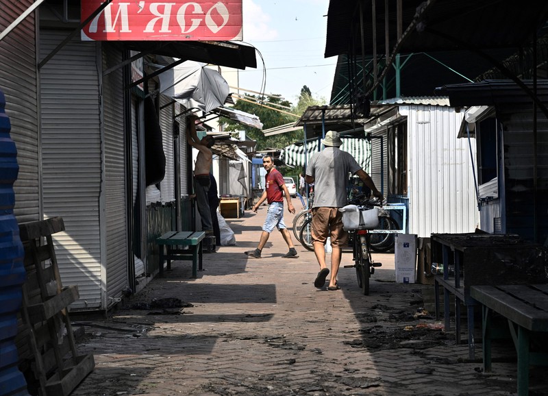 Kondisi pasar lokal Sloviansk, Ukraina sehari setelah serangan roket Rusia Seorang penduduk berjalan di antara puing-puing di samping sebuah rumah yang hancur sehari setelah serangan roket Rusia di pasar lokal Sloviansk, Ukraina, Senin (4/7/2022). Sedikitnya enam orang dilaporkan tewas setelah kota Sloviansk di wilayah Ukraina bagian timur dihantam gempuran kuat Rusia yang diduga menggunakan peluncur roket MLRS. (Photo by GENYA SAVILOV/AFP via Getty Images)