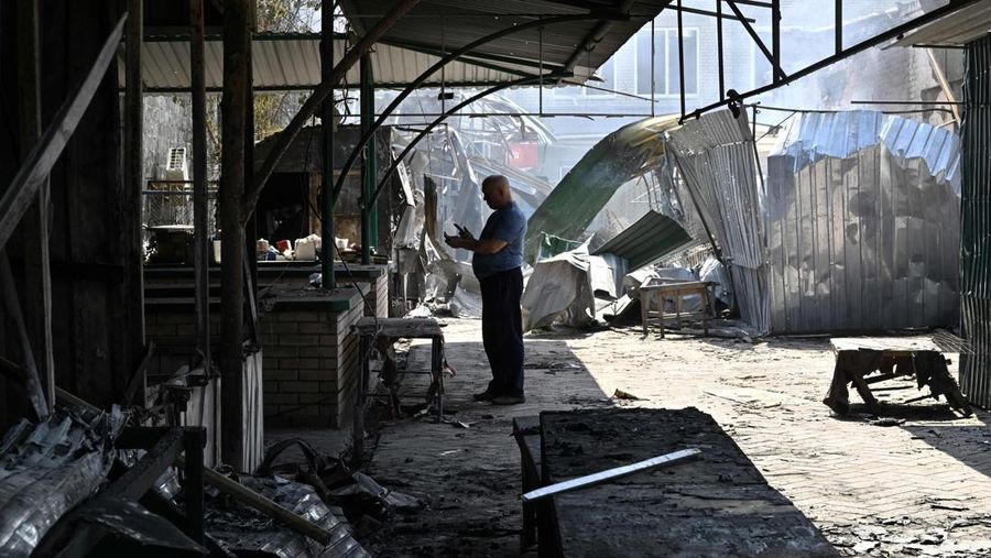 Seorang penduduk berjalan di antara puing-puing di samping sebuah rumah yang hancur sehari setelah serangan roket Rusia di pasar lokal Sloviansk, Ukraina, Senin (4/7/2022). Sedikitnya enam orang dilaporkan tewas setelah kota Sloviansk di wilayah Ukraina bagian timur dihantam gempuran kuat Rusia yang diduga menggunakan peluncur roket MLRS. (Photo by GENYA SAVILOV/AFP via Getty Images)
