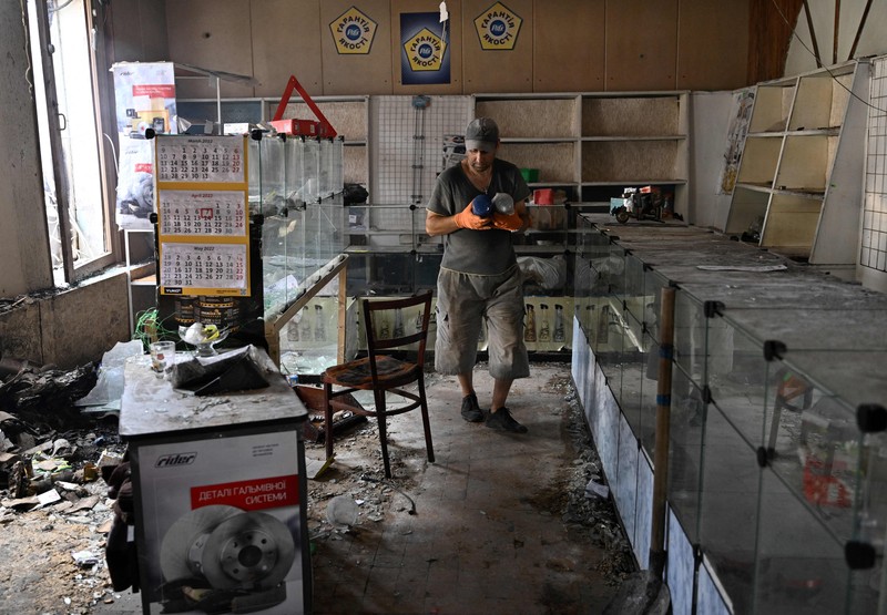 Kondisi pasar lokal Sloviansk, Ukraina sehari setelah serangan roket Rusia Seorang penduduk berjalan di antara puing-puing di samping sebuah rumah yang hancur sehari setelah serangan roket Rusia di pasar lokal Sloviansk, Ukraina, Senin (4/7/2022). Sedikitnya enam orang dilaporkan tewas setelah kota Sloviansk di wilayah Ukraina bagian timur dihantam gempuran kuat Rusia yang diduga menggunakan peluncur roket MLRS. (Photo by GENYA SAVILOV/AFP via Getty Images)