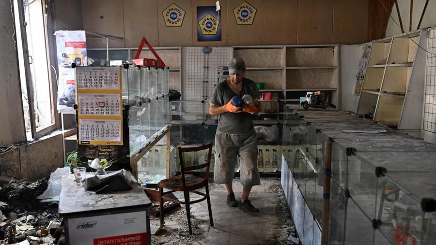 Seorang penduduk berjalan di antara puing-puing di samping sebuah rumah yang hancur sehari setelah serangan roket Rusia di pasar lokal Sloviansk, Ukraina, Senin (4/7/2022). Sedikitnya enam orang dilaporkan tewas setelah kota Sloviansk di wilayah Ukraina bagian timur dihantam gempuran kuat Rusia yang diduga menggunakan peluncur roket MLRS. (Photo by GENYA SAVILOV/AFP via Getty Images)